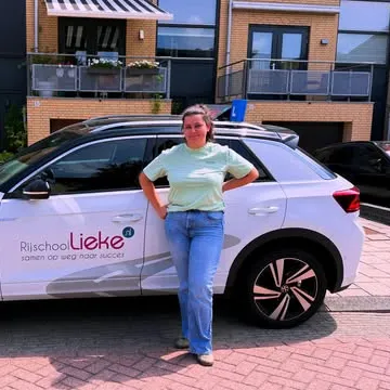 Leerling staat naast de lesauto van Rijschool Lieke
