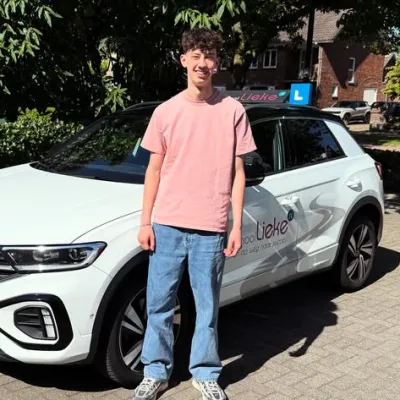 Leerling staat bij de lesauto van Rijschool Lieke
