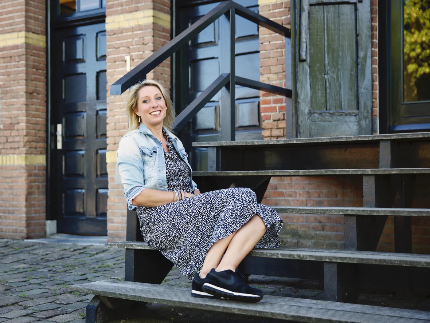 Lieke, rij-instructrice van Rijschool Lieke, lachend op een trap in Waalwijk